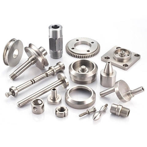 Assorted metal precision machined parts on white background.