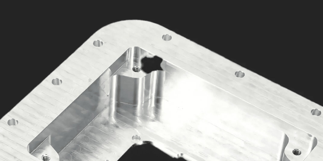 Precision-machined metal part with multiple cutouts and holes.