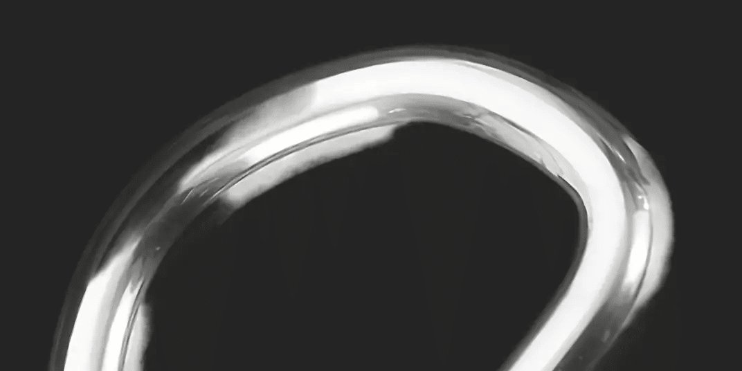 Shiny silver metal ring on dark background.