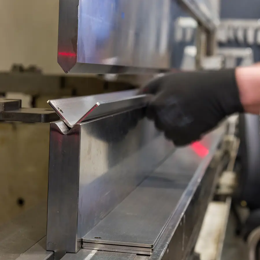 Metal sheet bending with industrial machine.