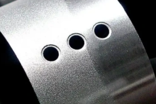 Close-up of metallic surface with three holes.