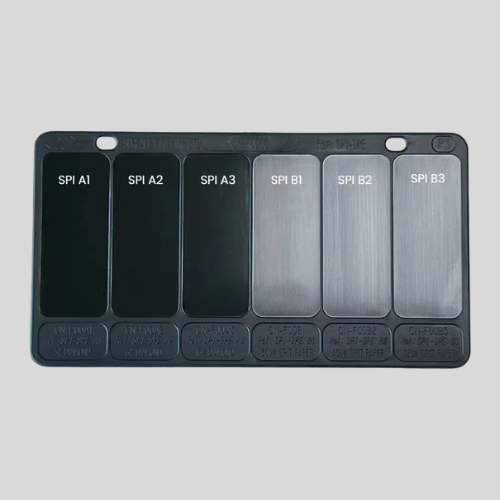 Six surface finish comparison standards on a plaque.